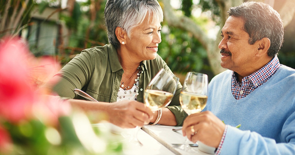 Retired couple enjoying wine together, reflecting the lifestyle benefits of comprehensive private wealth and retirement planning