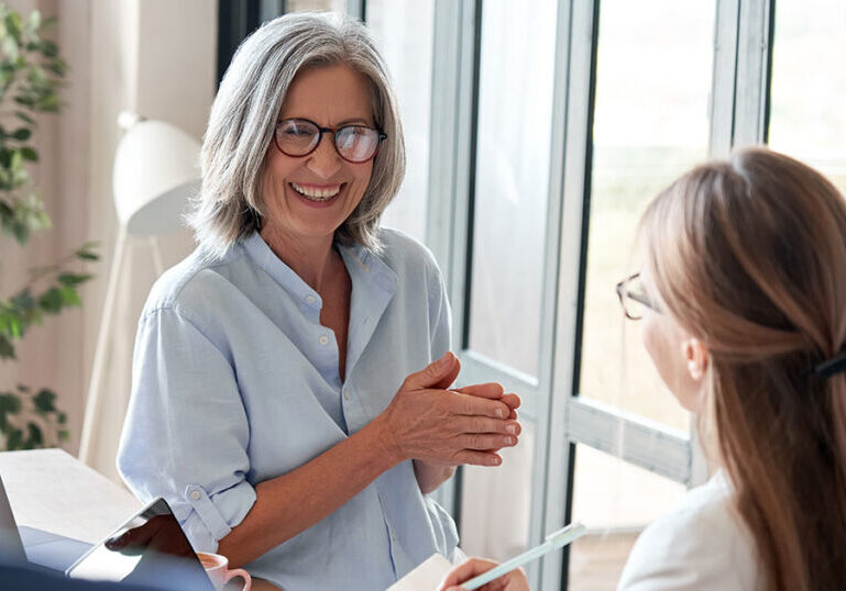 Woman discussing charitable remainder trust estate planning with two financial professionals in an office