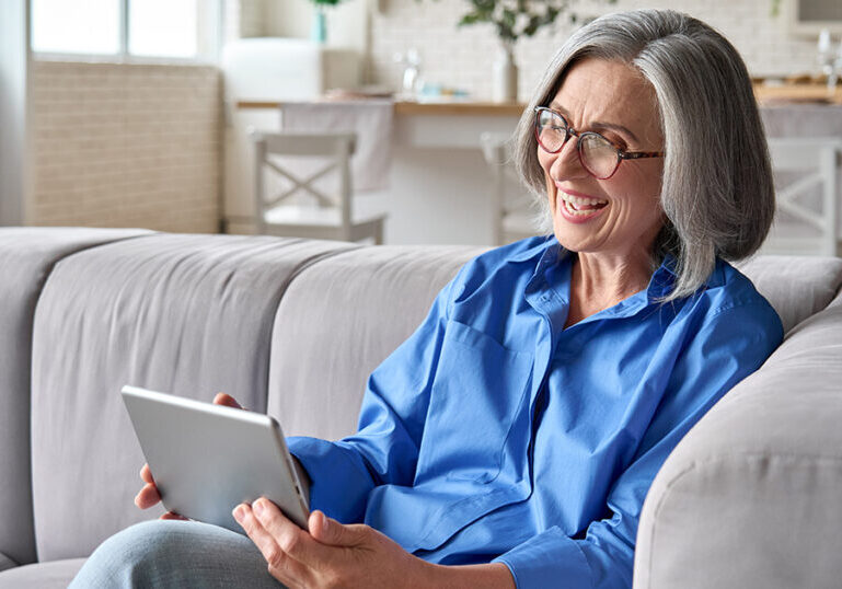 senior aged woman enjoys her iPad