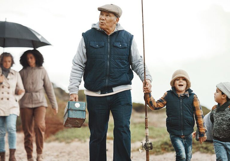Multigenerational family walking together on a beach for a fishing trip, representing how thoughtful family wealth planning can create shared experiences and lasting memories across generations