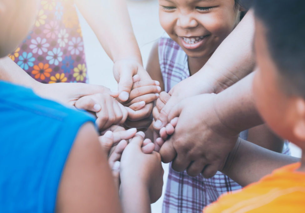 Children and parent holding hands and playing together with unity and teamwork