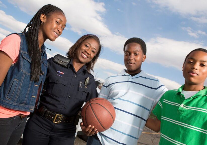 EMERGENCY SERVICES - Policeman talking to kids on the street