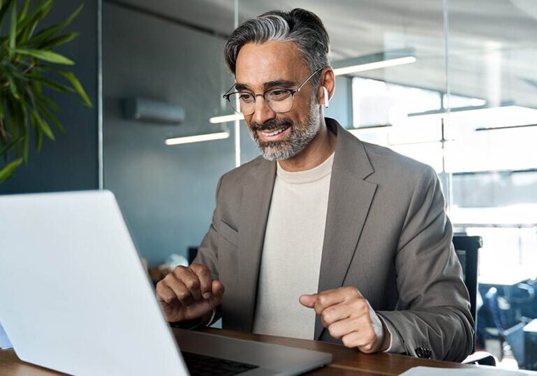 A man looks at documents on his laptop