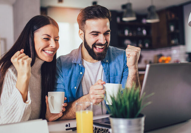 Happy couple looking at their positive financial results